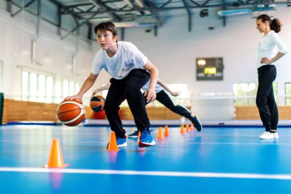 Crianças praticam basquete em quadra escolar inspiradas pelas Olimpíadas.