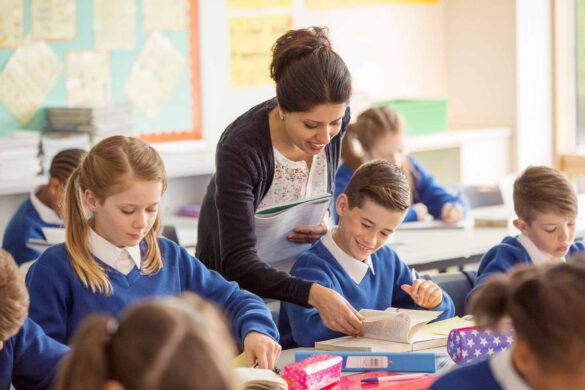 Crianças recebem orientação da professora de inglês na sala de aula.