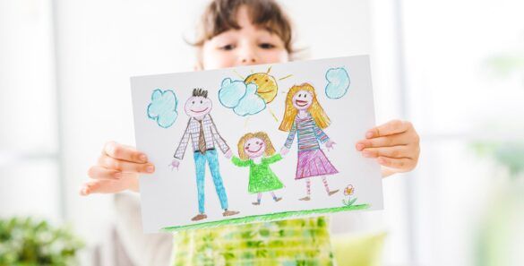 Criança mostra desenho que pintou sobre o dia da família na escola