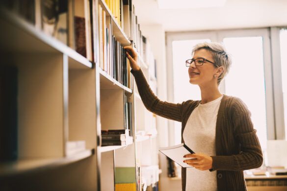 Gestor escolar tateando estante de livros em busca de novas leituras
