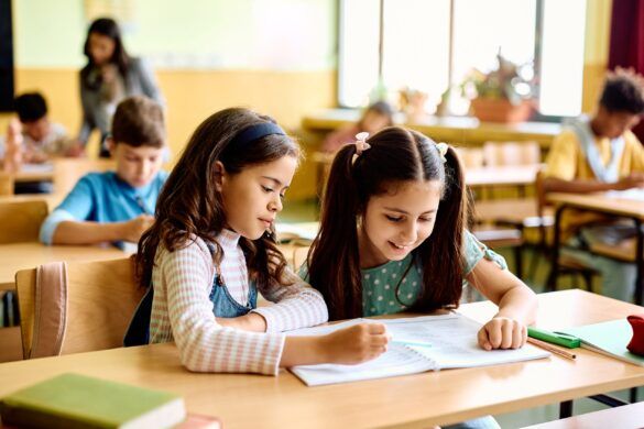 Crianças sendo estimuladas à leitura e interpretação textual em sala de aula